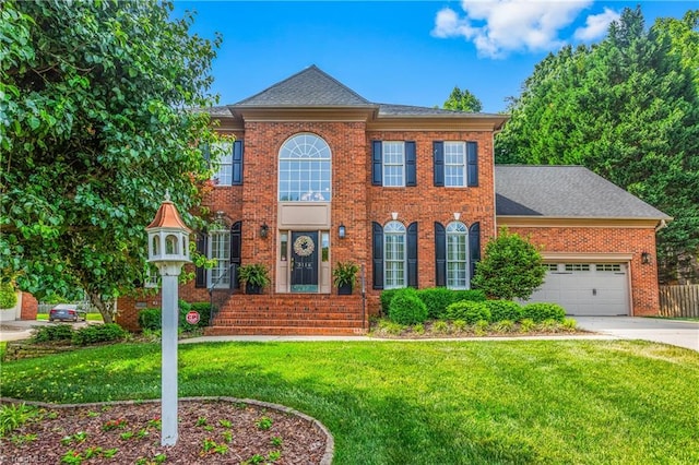 3116 Lodge Dr, Jamestown, NC 27282 - colonial-style house with brick siding, a front yard, concrete driveway, an attached garage, and a shingled roof