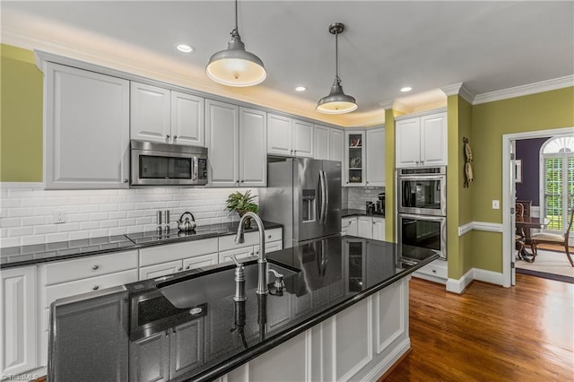 3116 Lodge Dr, Jamestown, NC 27282 - kitchen with appliances with stainless steel finishes, crown molding, pendant lighting, decorative backsplash, and dark wood finished floors
