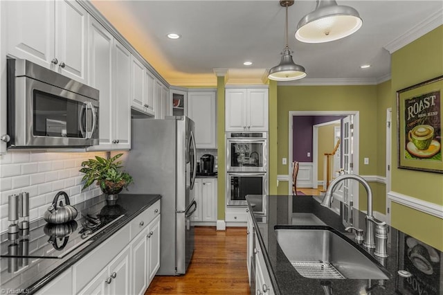 3116 Lodge Dr, Jamestown, NC 27282 - kitchen with stainless steel appliances, a sink, ornamental molding, decorative backsplash, and dark stone counters