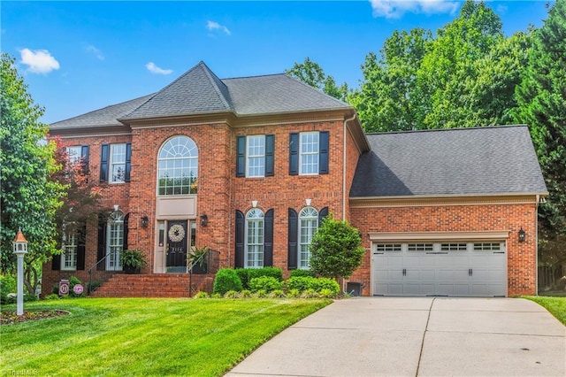 3116 Lodge Dr, Jamestown, NC 27282 - georgian-style home with driveway, a front yard, brick siding, and a garage