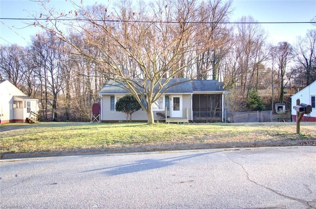view of front facade with a sunroom and a front lawn