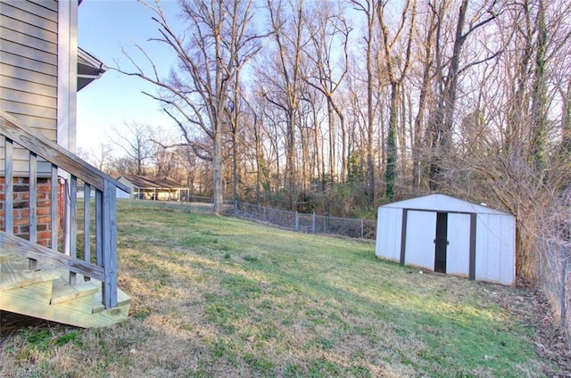 view of yard featuring a fenced backyard, a storage unit, and an outbuilding