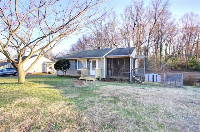 single story home with a front lawn, a storage shed, a sunroom, an outbuilding, and a chimney