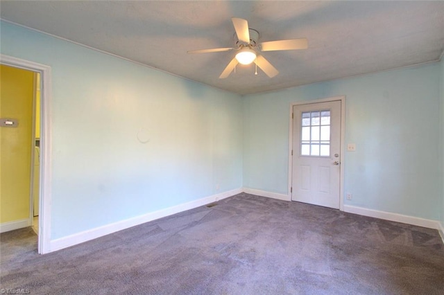 carpeted empty room with ceiling fan and baseboards