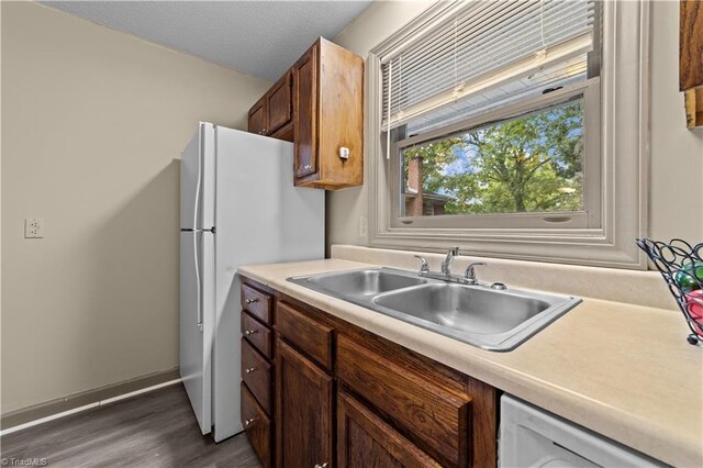 kitchen featuring white appliances, sink, and dark wood-type flooring