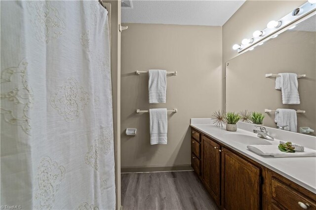 bathroom featuring hardwood / wood-style floors, a textured ceiling, and vanity