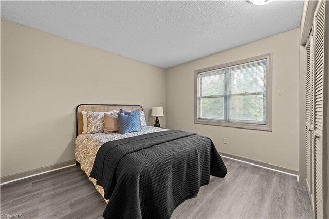 bedroom with wood-type flooring and a textured ceiling