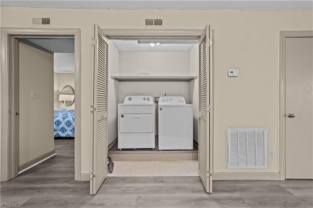 laundry room featuring hardwood / wood-style flooring and washer and dryer