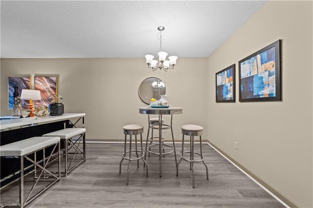 dining area with light hardwood / wood-style flooring and a chandelier