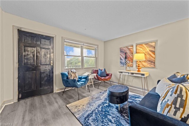 sitting room with hardwood / wood-style flooring and a textured ceiling