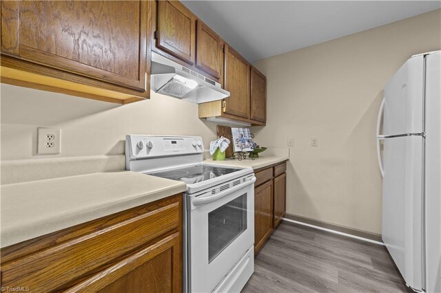 kitchen featuring light hardwood / wood-style floors and white appliances