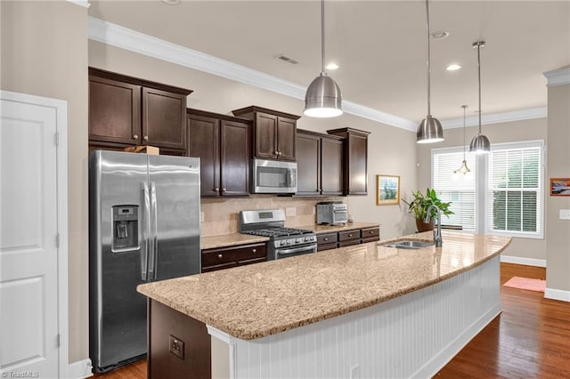 kitchen with sink, an island with sink, decorative light fixtures, and stainless steel appliances