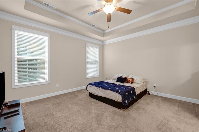 bedroom featuring crown molding, a raised ceiling, light carpet, and ceiling fan