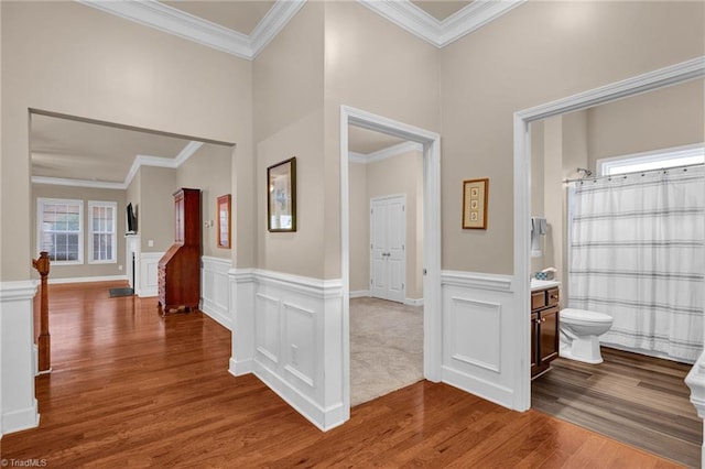 hallway with ornamental molding and hardwood / wood-style floors