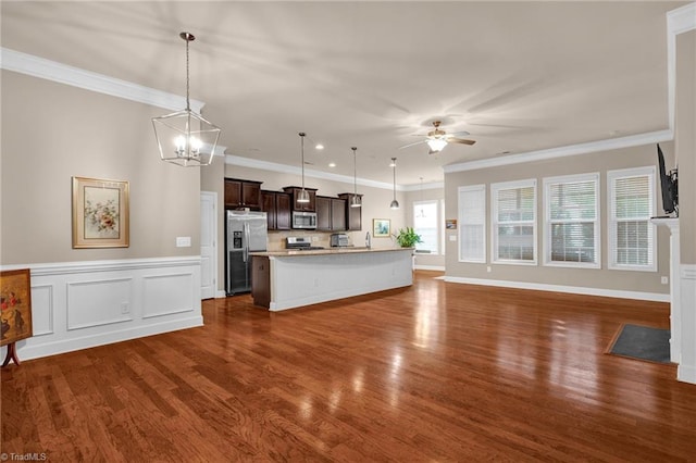 kitchen featuring dark brown cabinets, hanging light fixtures, stainless steel appliances, and a kitchen island