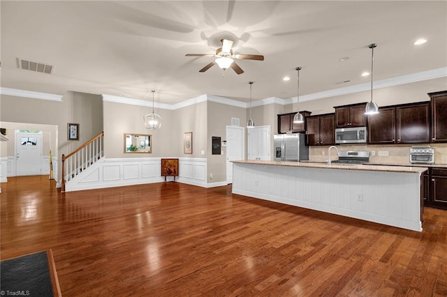 kitchen featuring appliances with stainless steel finishes, a kitchen island with sink, and dark wood-type flooring