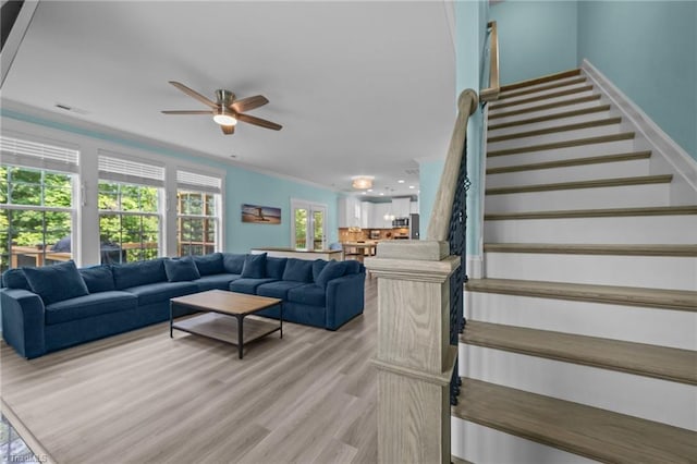 7615 Mary Ellen Ct, Greensboro, NC 27409 - living room with a ceiling fan, stairs, light wood-type flooring, and crown molding
