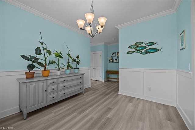 7615 Mary Ellen Ct, Greensboro, NC 27409 - dining room featuring a chandelier, light wood finished floors, wainscoting, ornamental molding, and a decorative wall
