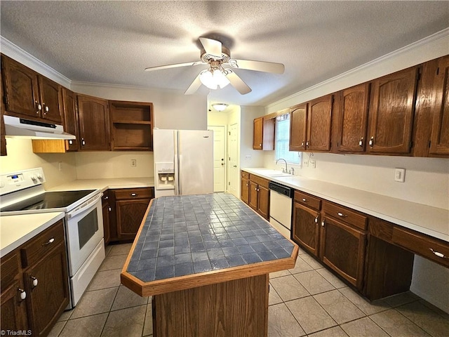 kitchen with sink, white appliances, light tile patterned floors, and a kitchen island