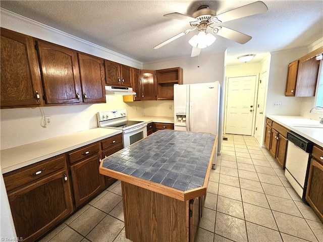 kitchen with sink, a center island, white appliances, ceiling fan, and a textured ceiling