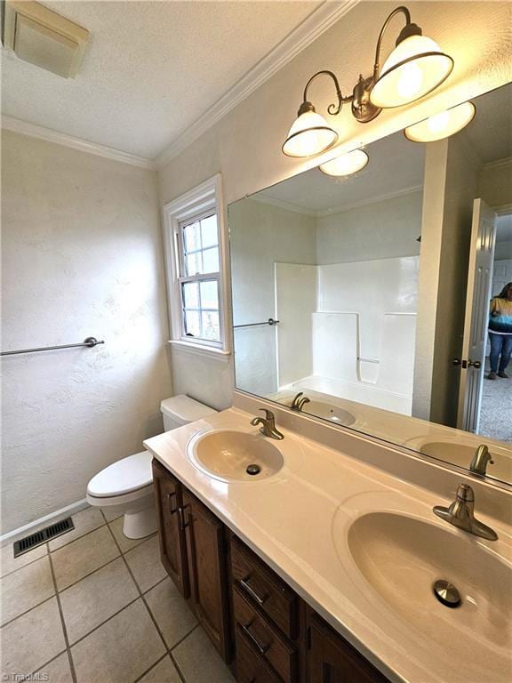 bathroom with tile patterned flooring, vanity, ornamental molding, a textured ceiling, and toilet