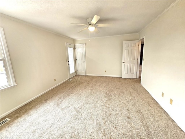 empty room with ceiling fan, ornamental molding, carpet floors, and a textured ceiling