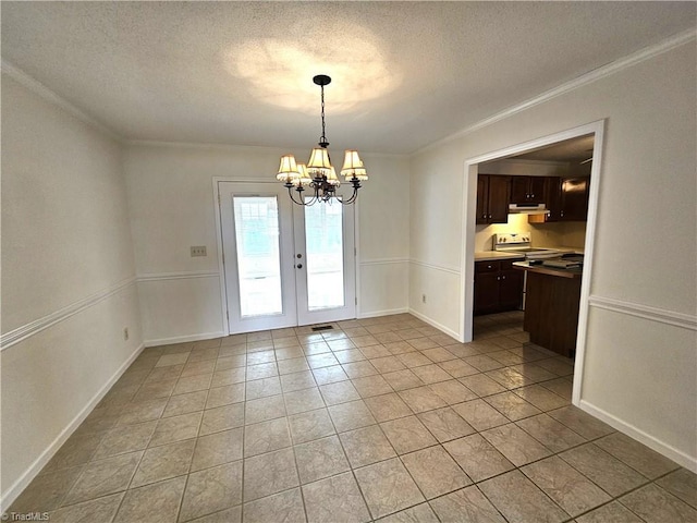 unfurnished dining area with an inviting chandelier, ornamental molding, light tile patterned flooring, and a textured ceiling