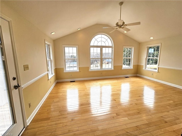 unfurnished room featuring lofted ceiling, light hardwood / wood-style flooring, and plenty of natural light