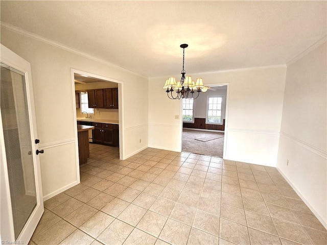 unfurnished dining area with crown molding, light tile patterned floors, and a notable chandelier