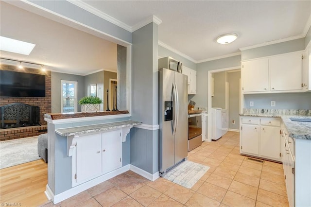 kitchen with stainless steel appliances, open floor plan, light countertops, and white cabinetry