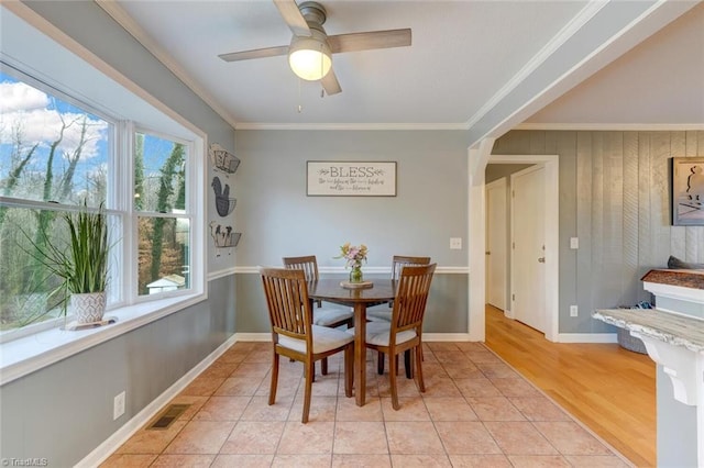 dining area featuring crown molding, visible vents, light tile patterned flooring, ceiling fan, and baseboards