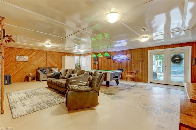 living area featuring wooden walls, concrete floors, and pool table