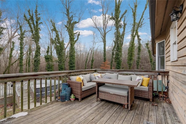 wooden deck featuring an outdoor living space and a wooded view