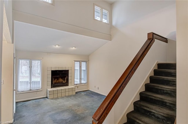 stairway with carpet, a healthy amount of sunlight, and a fireplace