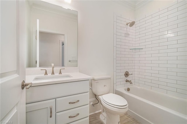 full bathroom featuring vanity, tiled shower / bath combo, crown molding, hardwood / wood-style flooring, and toilet