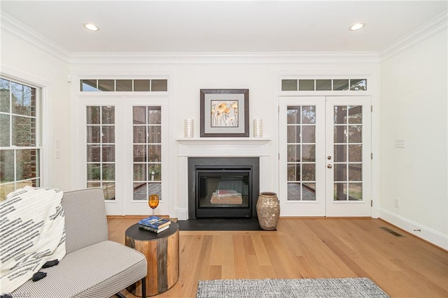 living area featuring crown molding, french doors, and wood-type flooring