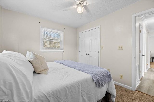 carpeted bedroom featuring ceiling fan and a closet