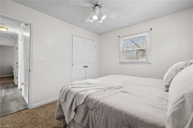 carpeted bedroom featuring ceiling fan, a textured ceiling, and a closet