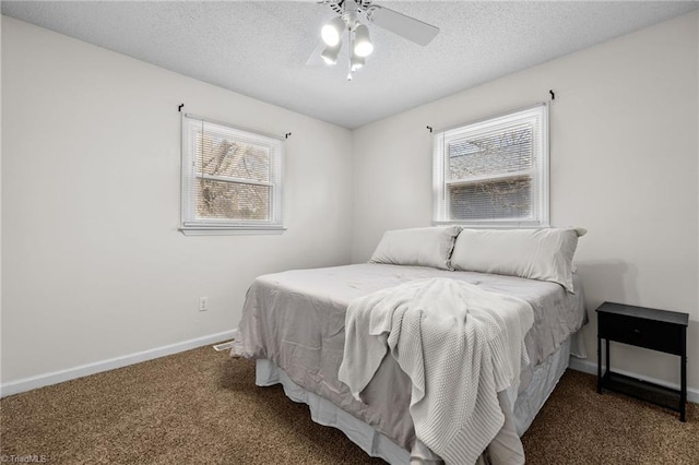 bedroom featuring ceiling fan, dark carpet, and a textured ceiling