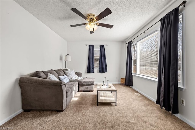 carpeted living room featuring ceiling fan and a textured ceiling