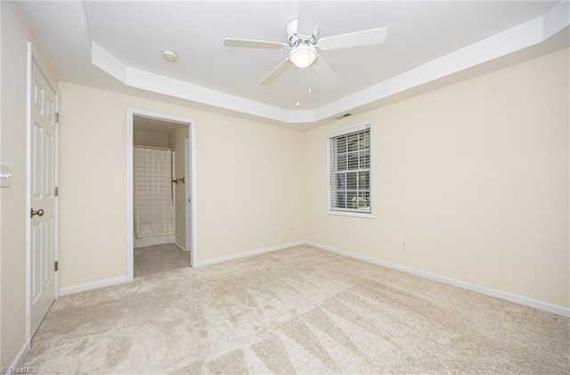 711 Sunset Ave Unit B, Asheboro, NC 27203 - unfurnished bedroom with a tray ceiling, carpet flooring, baseboards, connected bathroom, and a ceiling fan
