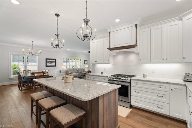 1623 Angus Ridge Dr, Kernersville, NC 27284 - kitchen featuring stainless steel gas range oven, a chandelier, ornamental molding, white cabinets, and a kitchen island