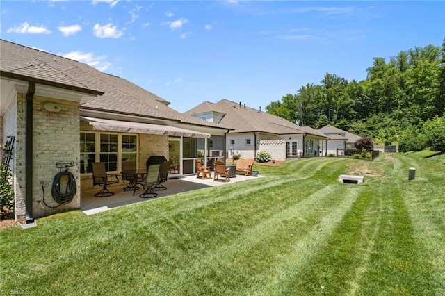 1623 Angus Ridge Dr, Kernersville, NC 27284 - rear view of property with a patio area, a lawn, roof with shingles, and brick siding
