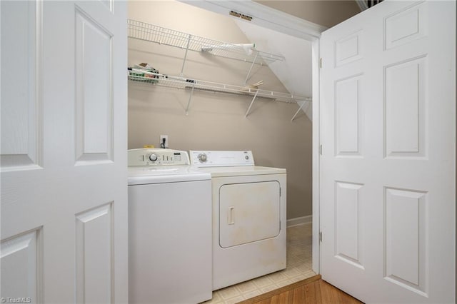 washroom with washing machine and clothes dryer and light hardwood / wood-style floors