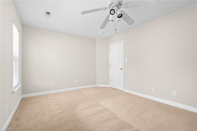 spare room with light colored carpet and ceiling fan