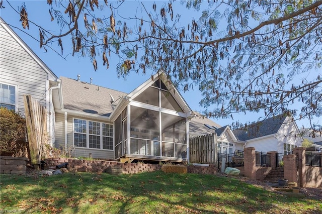 back of property with a lawn and a sunroom