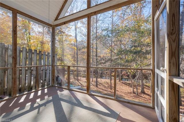 unfurnished sunroom featuring lofted ceiling and plenty of natural light