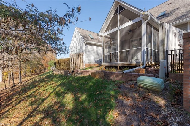 rear view of property featuring a sunroom and a yard