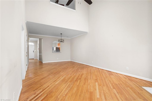 unfurnished living room with light hardwood / wood-style flooring, ceiling fan, and crown molding