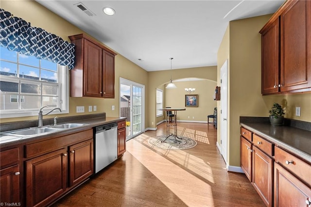 kitchen featuring a healthy amount of sunlight, dark wood-type flooring, stainless steel dishwasher, and sink